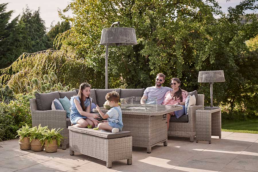 Family enjoying dinner outdoors keeping warm with electric garden heaters