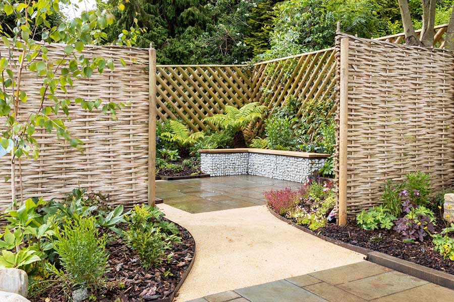 Seating area surround by Hazel screens and plants on the feature Garden at Oxford Garden Centre